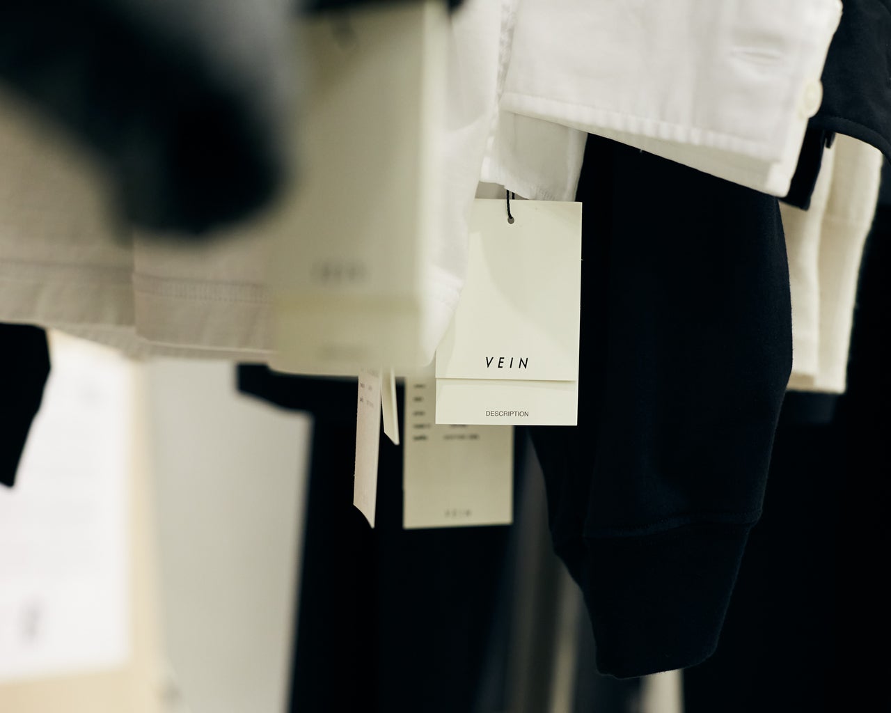 榎本光希さんのアトリエに並ぶVEINの洋服とタグ