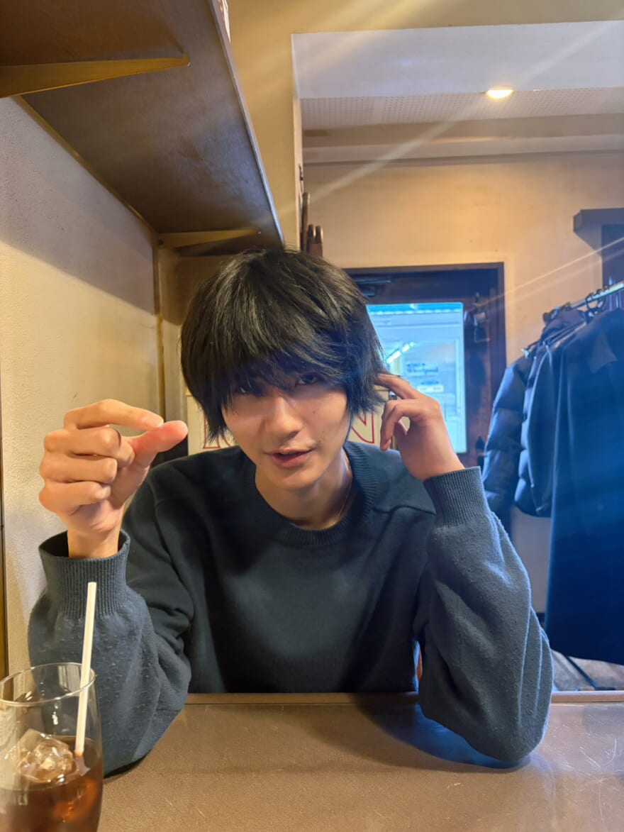 カフェにいる髙橋大翔。黒髪で、前髪が長い。