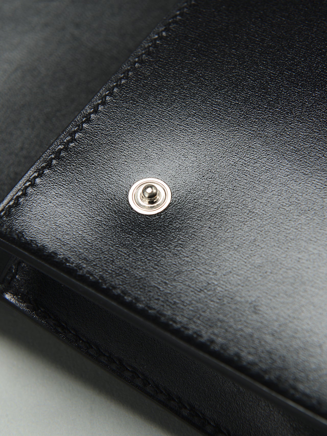 エルメスの黒い「ウォレットバッグ／エルメスナップ」のボタン