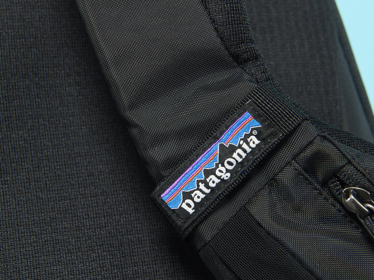 パタゴニアの黒いアトム・スリング 8L バッグのロゴ寄り