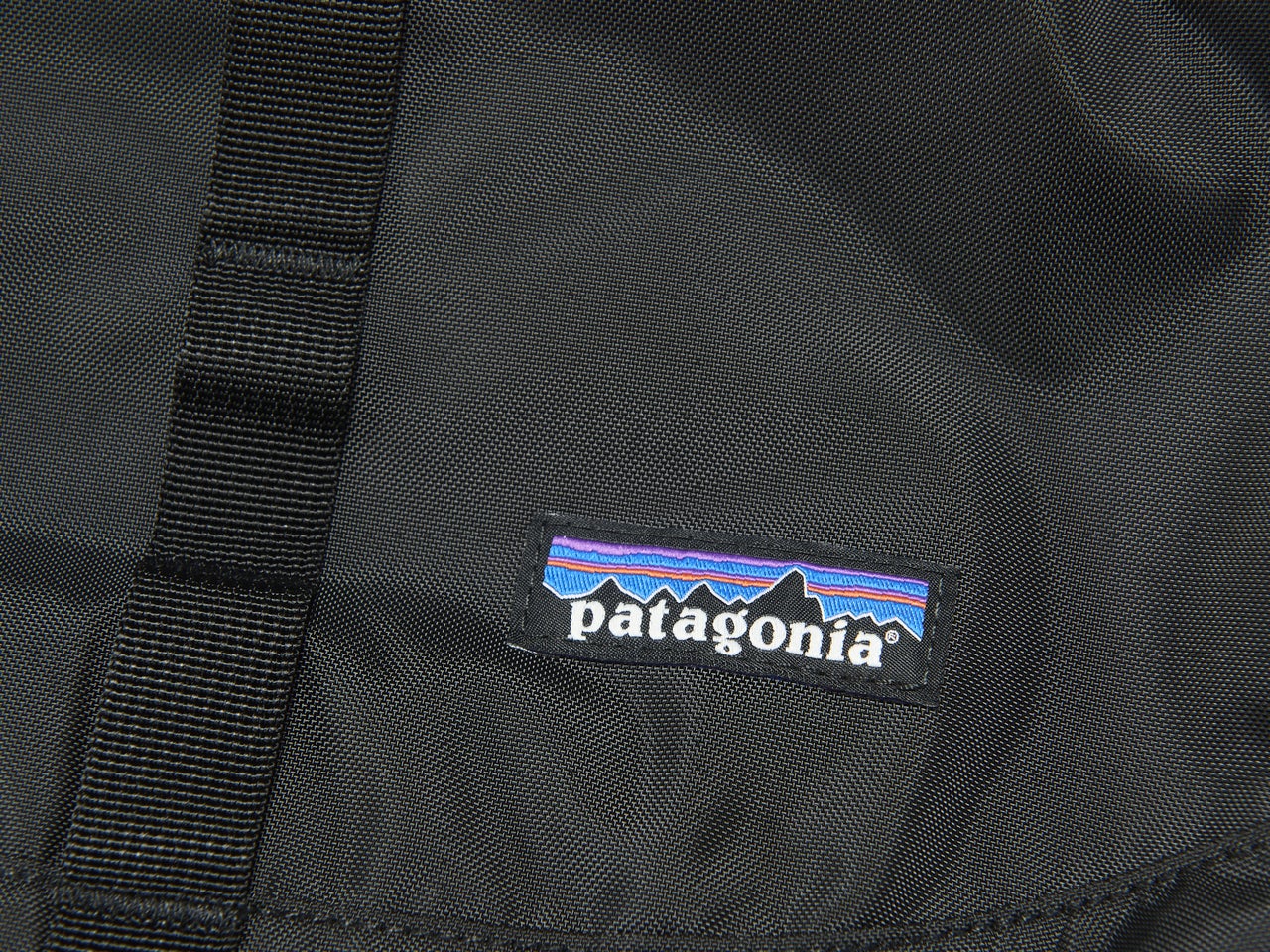 パタゴニアの黒いレフュジオ・デイパック 26L バッグのロゴ