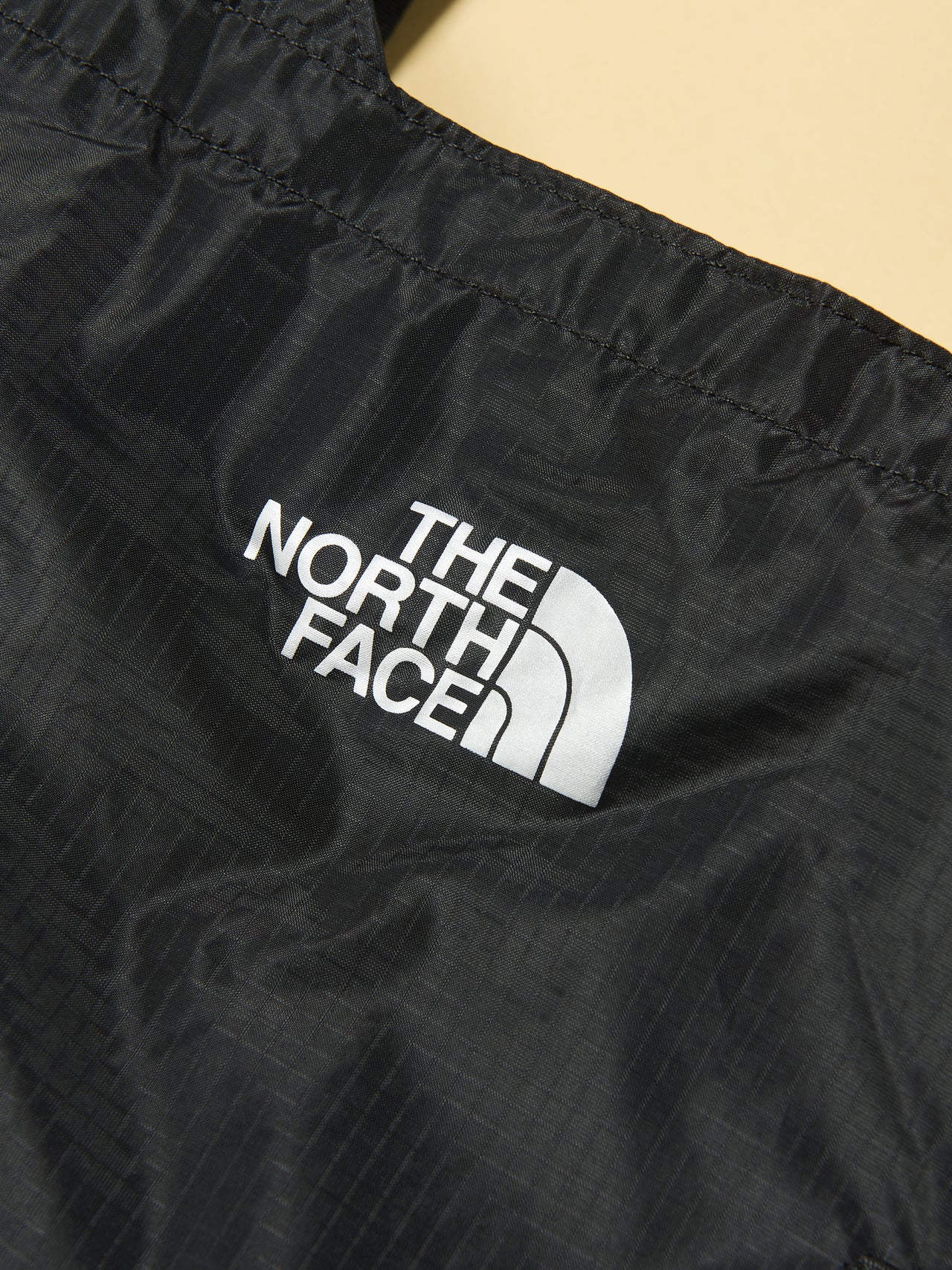 ザ・ノース・フェイスの黒いメイフライトート バッグのブランドロゴ