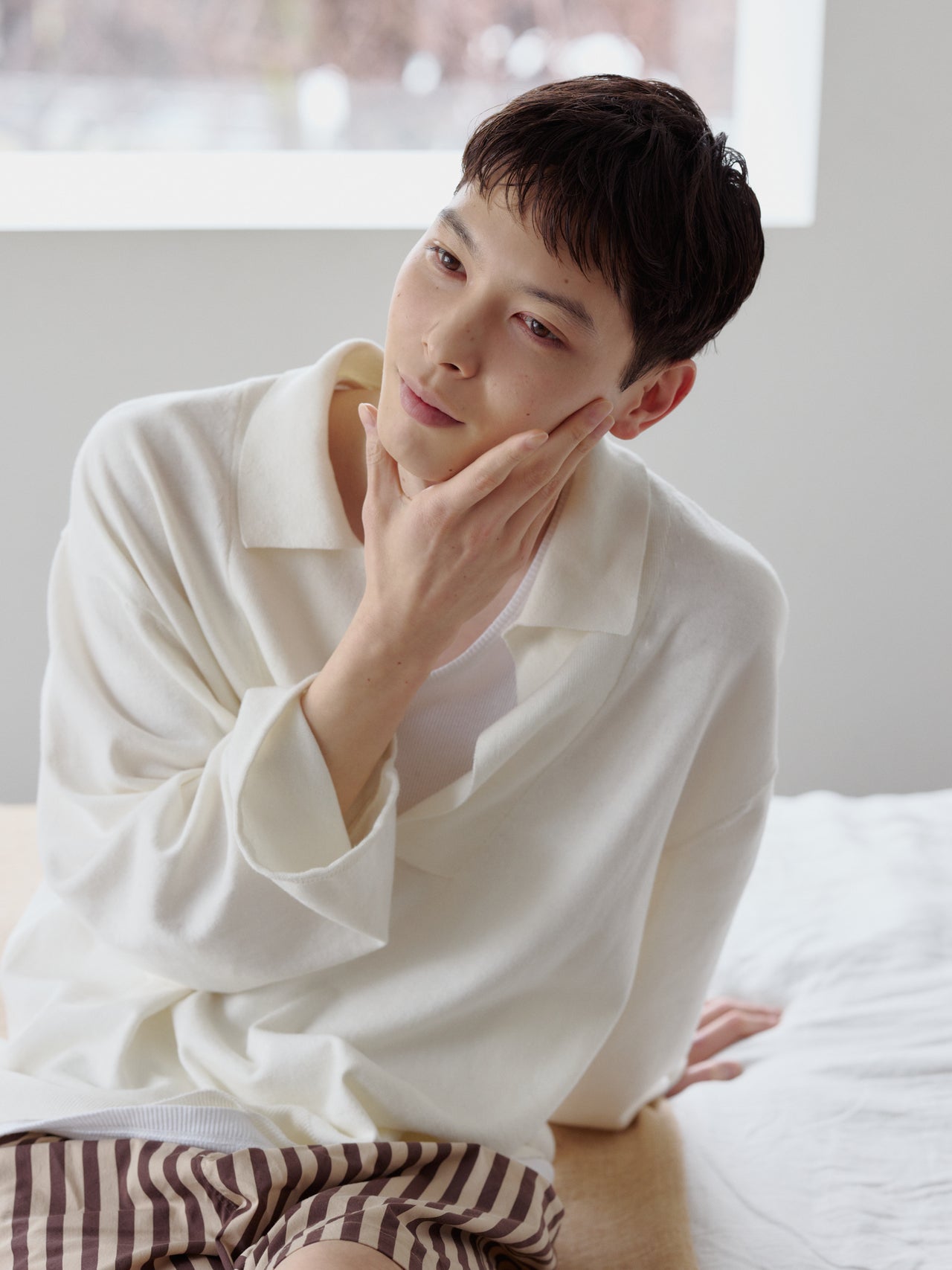 脱毛処理しツルツルになった頬を触る守屋光治さん