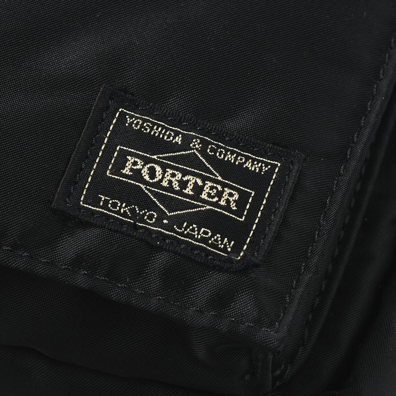 エディターが買ってよかった「ポーター／タンカー」の愛用黒バッグSling Bagのロゴ