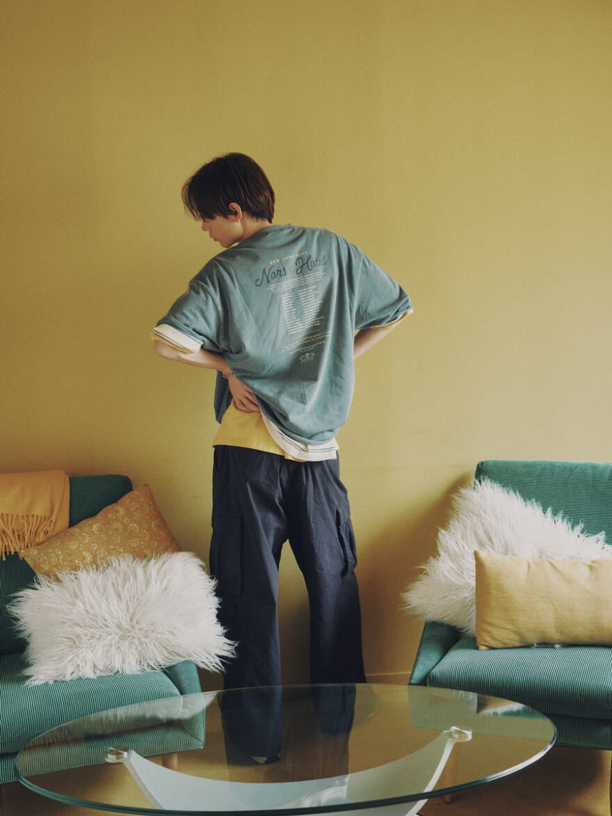 ニコアンドのTシャツのバックプリントを見せる水沢林太郎