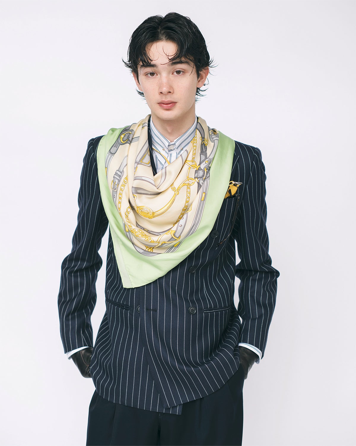 クラシカルなチョークストライプ柄のダブルスーツを着用した栄莉弥