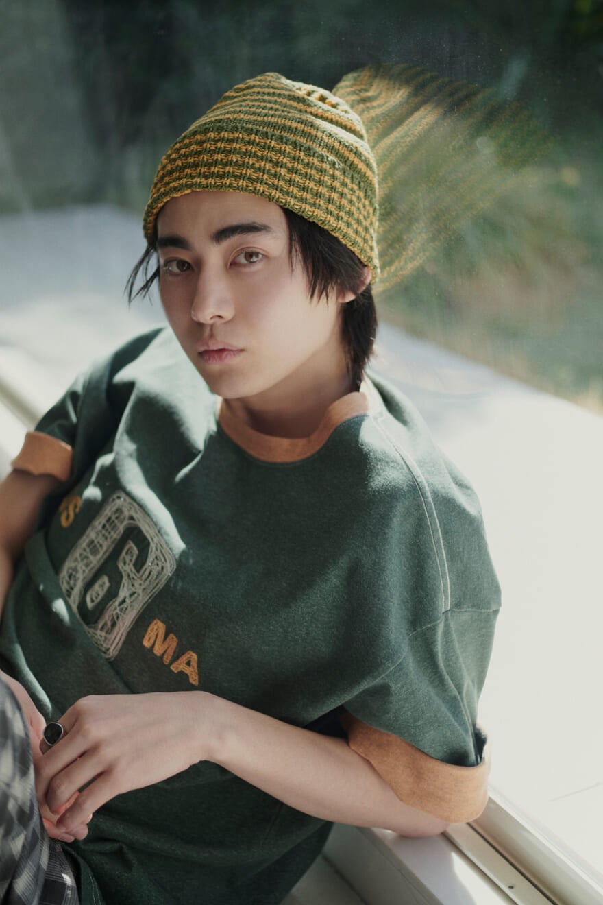 ニコアンドの2026年春夏新作のロゴTシャツに、ニットキャップを合わせてコーディネートした豊田裕大さん