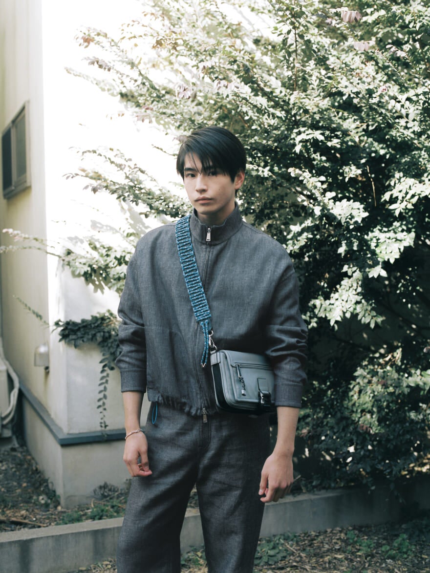 FENDIのデニムセットアップと、バッグ「フェンディ フラックス メッセンジャー」を着用する中沢元紀さん