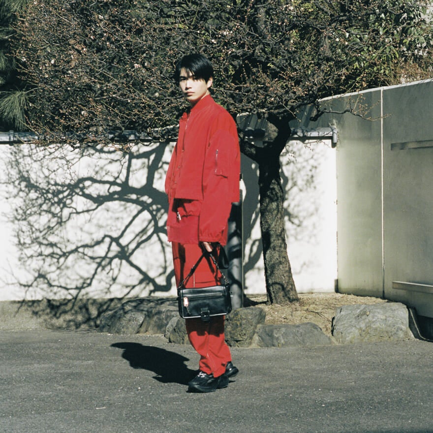 FENDIの赤のナイロンブルゾンとパンツのセットアップを着用する中沢元紀さん