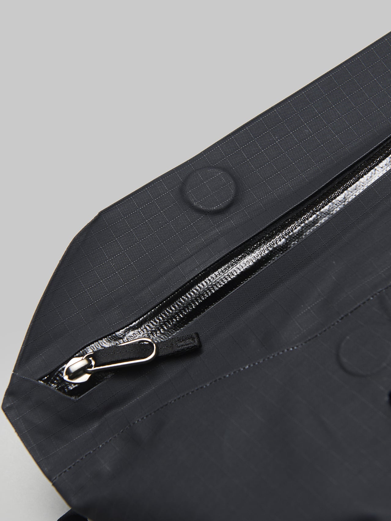 アークテリクスの黒いグランヴィル ショルダー バッグのマグネット式のフラップ＆止水ジップ