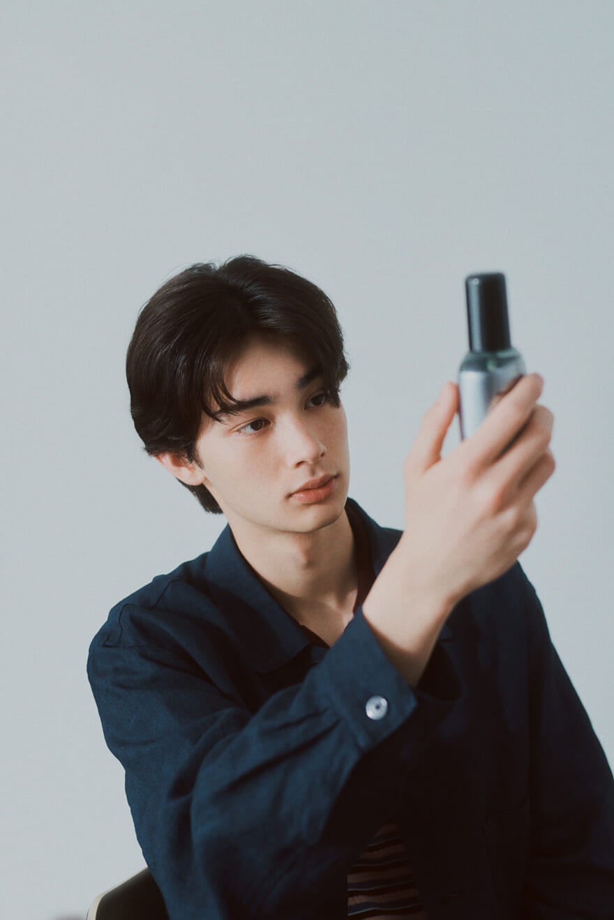 ウーノ(uno)の4Dスカルプエッセンスを手に取るモデルの栄莉弥さん