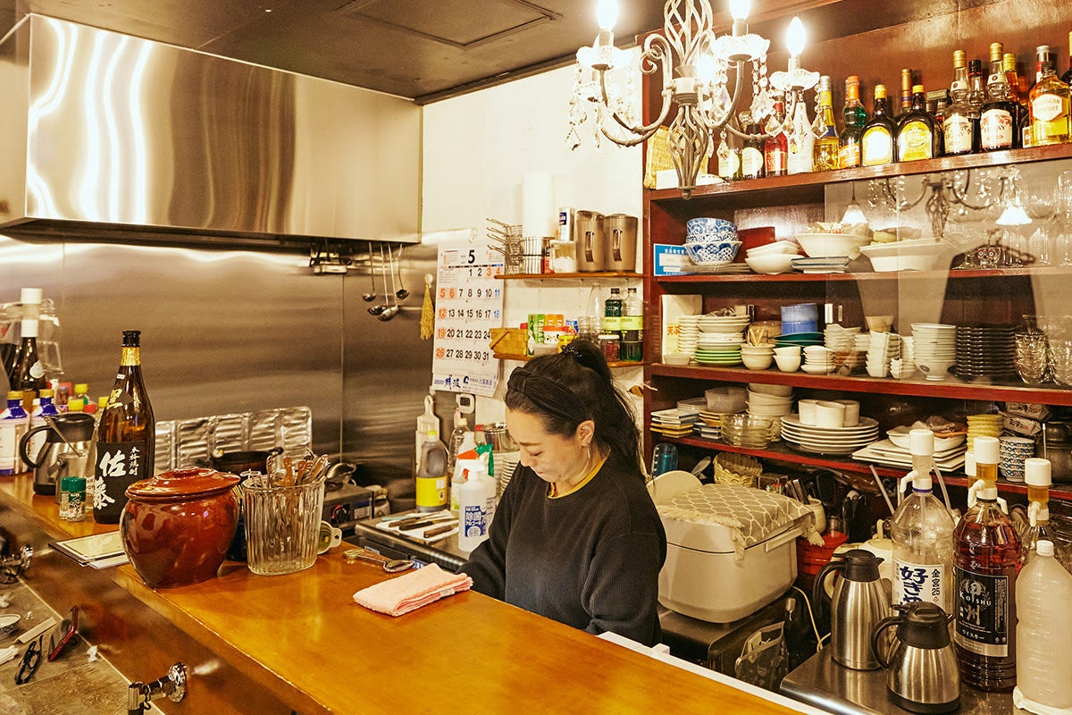 かねまん一階カウンターでお酒をつくるママ