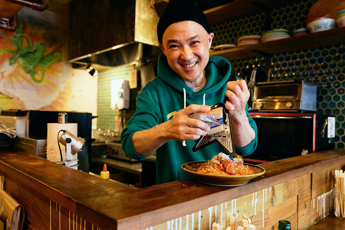 「高円寺メタルめし」ギターの形をしたチーズシュレッダーでパスタにチーズを削っているヤスさん2