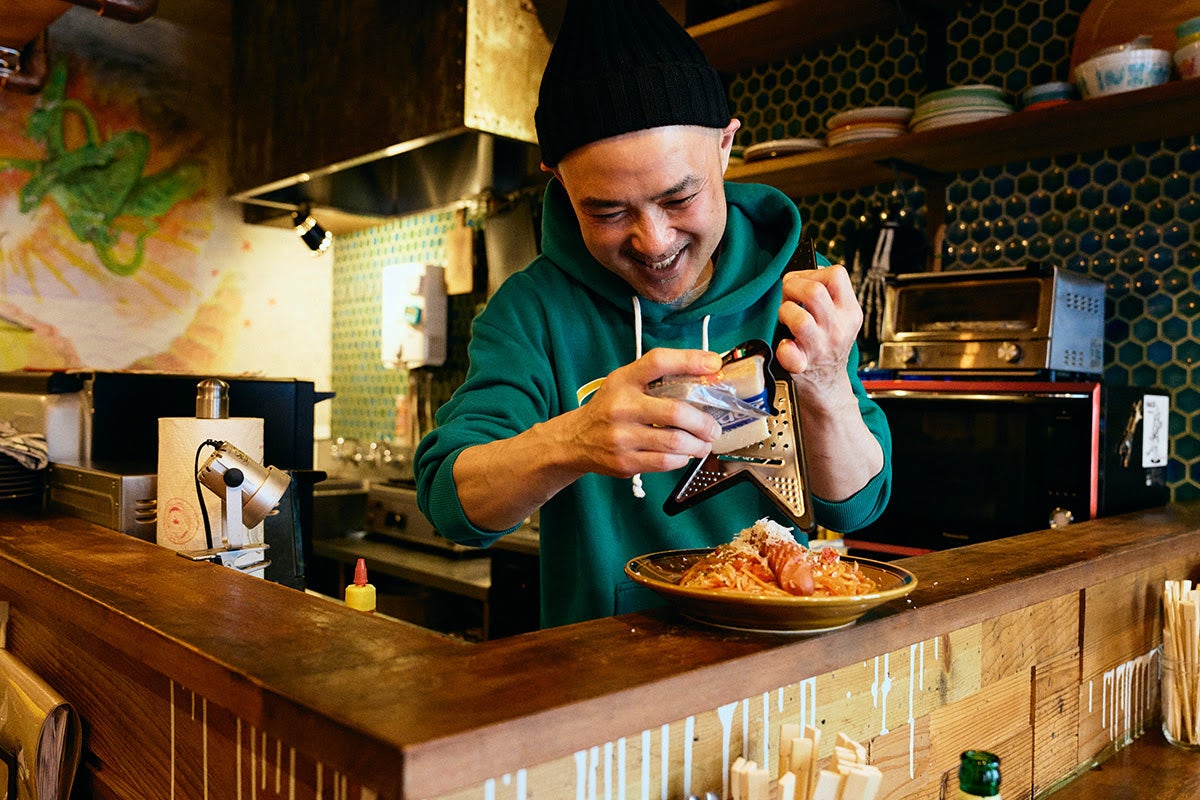 「高円寺メタルめし」ギターの形をしたチーズシュレッダーでパスタにチーズを削っているヤスさん3