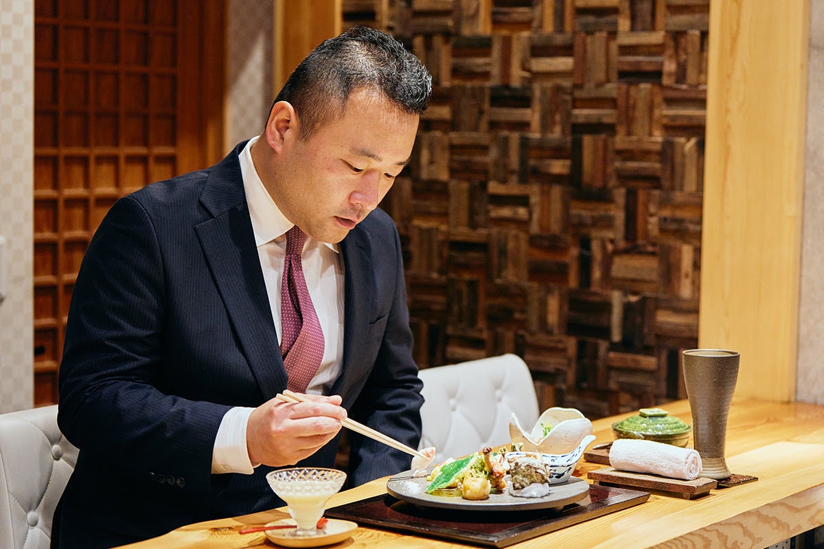 株式会社アーブ代表岡野辰太郎さんが「やまぼうし」のカウンターで食事をしている様子1