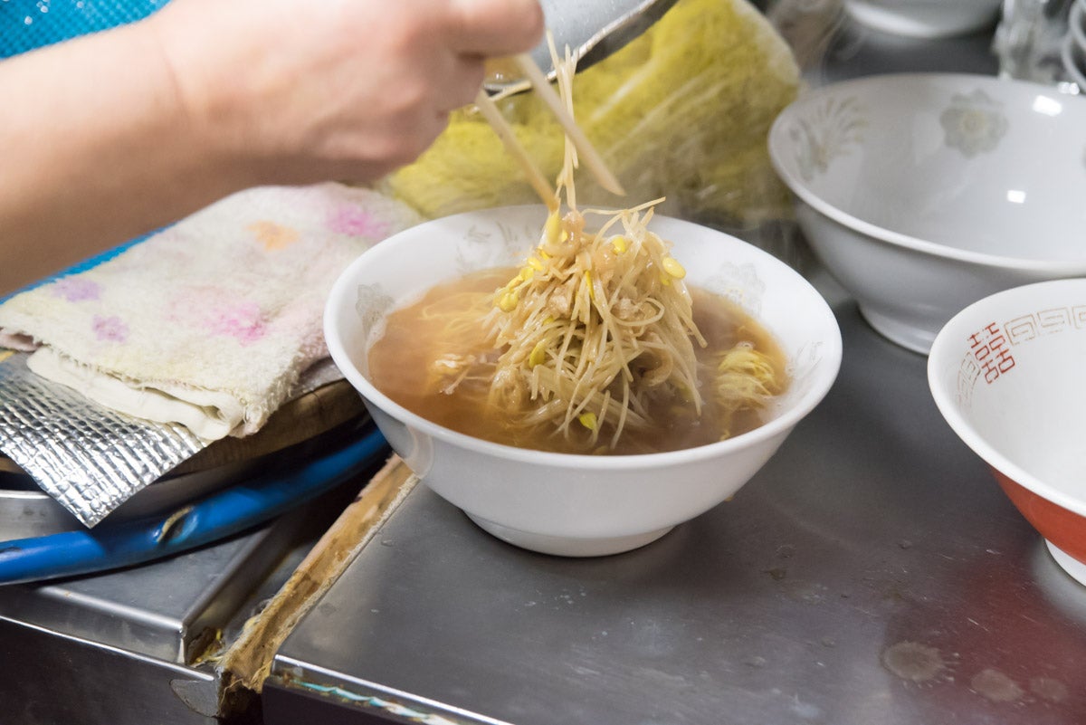 青森県大鰐町『山崎食堂』大鰐温泉もやしをラーメンに盛り付けている様子
