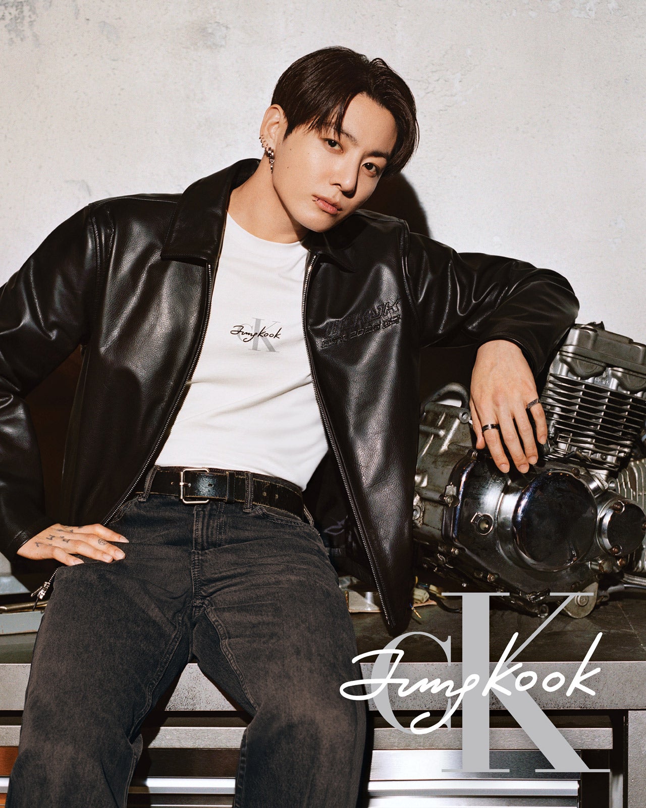 ジョングク(BTS)さんとカルバン・クラインとのコラボレーション。レザージャケットとロゴTシャツ、デニムを着用したジョングクさん
