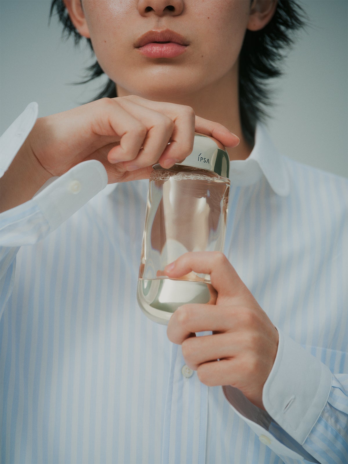 イプサの化粧水のふたを開ける豊田裕大さん