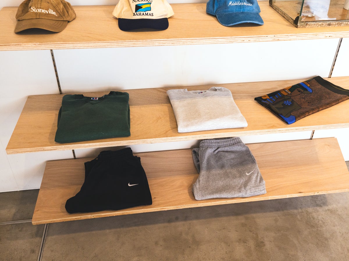 キャップやTシャツ、スウェットパンツが置かれたラック。