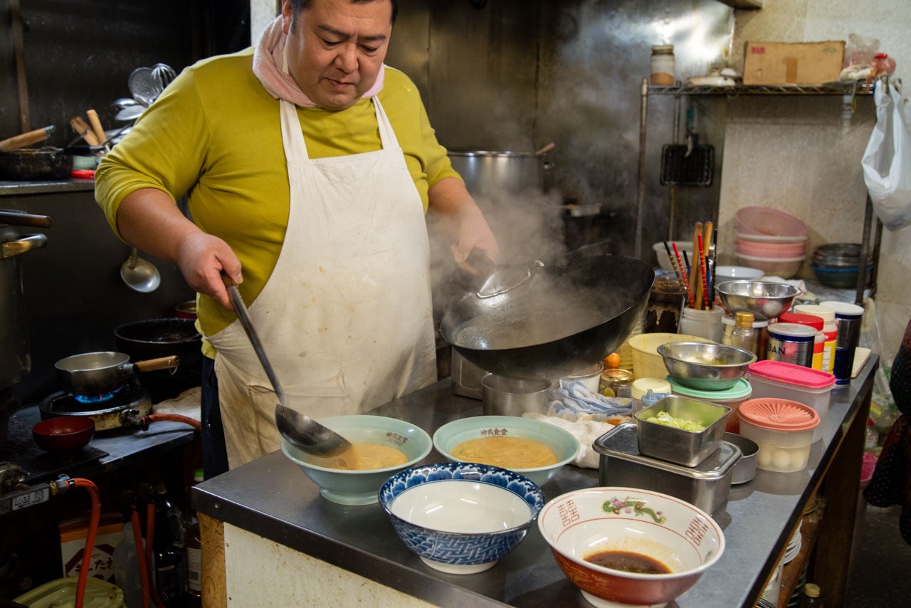 青森県つがる市『神武食堂』担々麺や手もみ中華のスープを丼に注ぐ店主