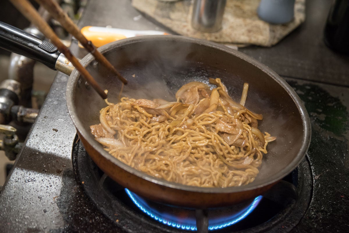 青森県平川市『大十食堂』タマネギと豚肉をソースで味付けている様子