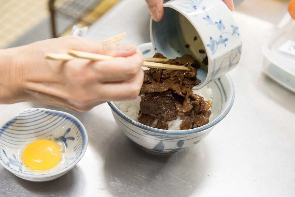 熊本県熊本市『山本屋食堂』ツヤツヤの白ごはんが盛られた丼に、馬肉、が盛られていく様子