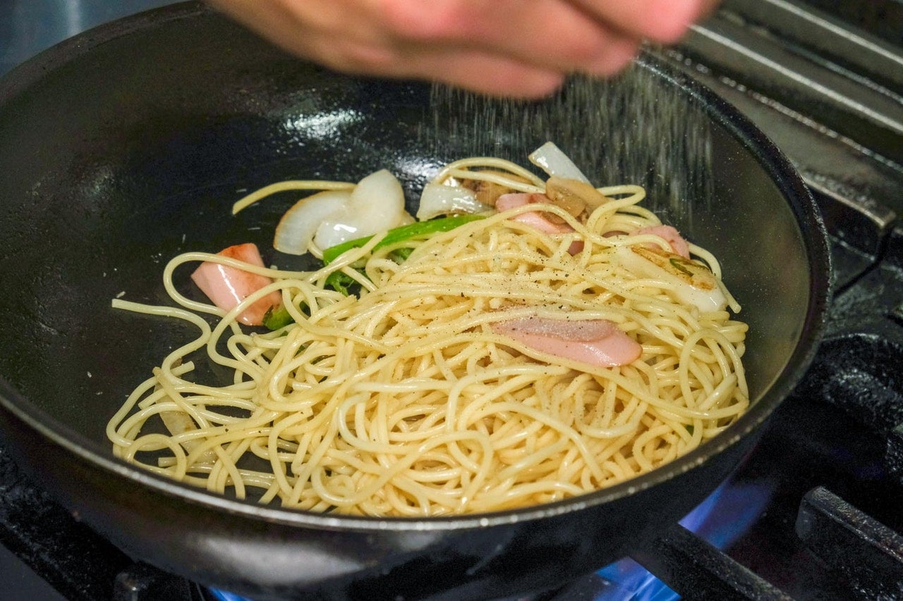 東京都中野区『野方食堂』フライパンで野菜と魚肉ソーセージを炒めている様子