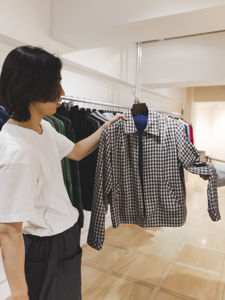 チェックのブルゾンを手に取る根本さん