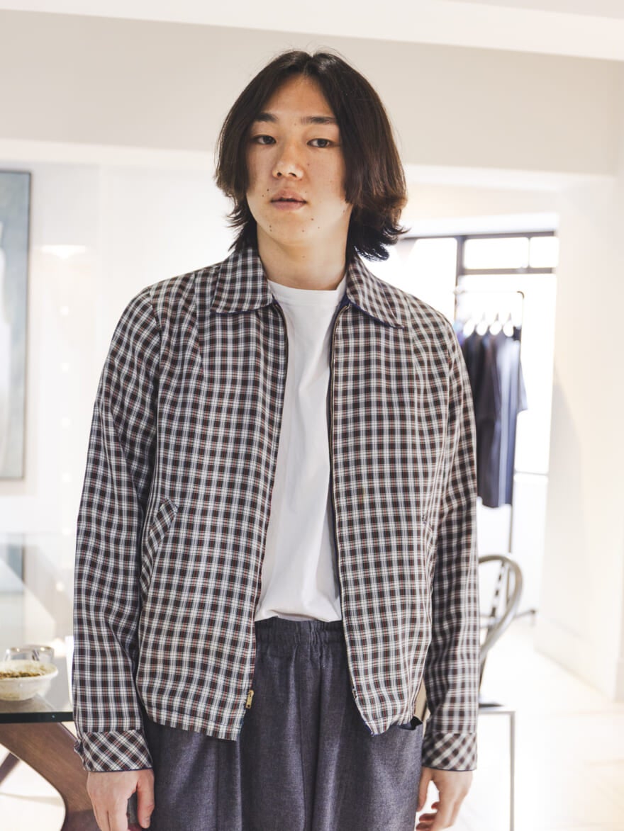 チェックのブルゾンを試着する根本さん