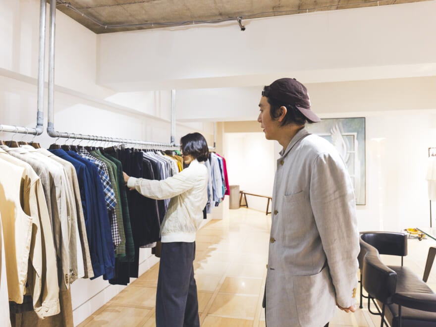 ラックを漁る根本さんを見ている楠本さん
