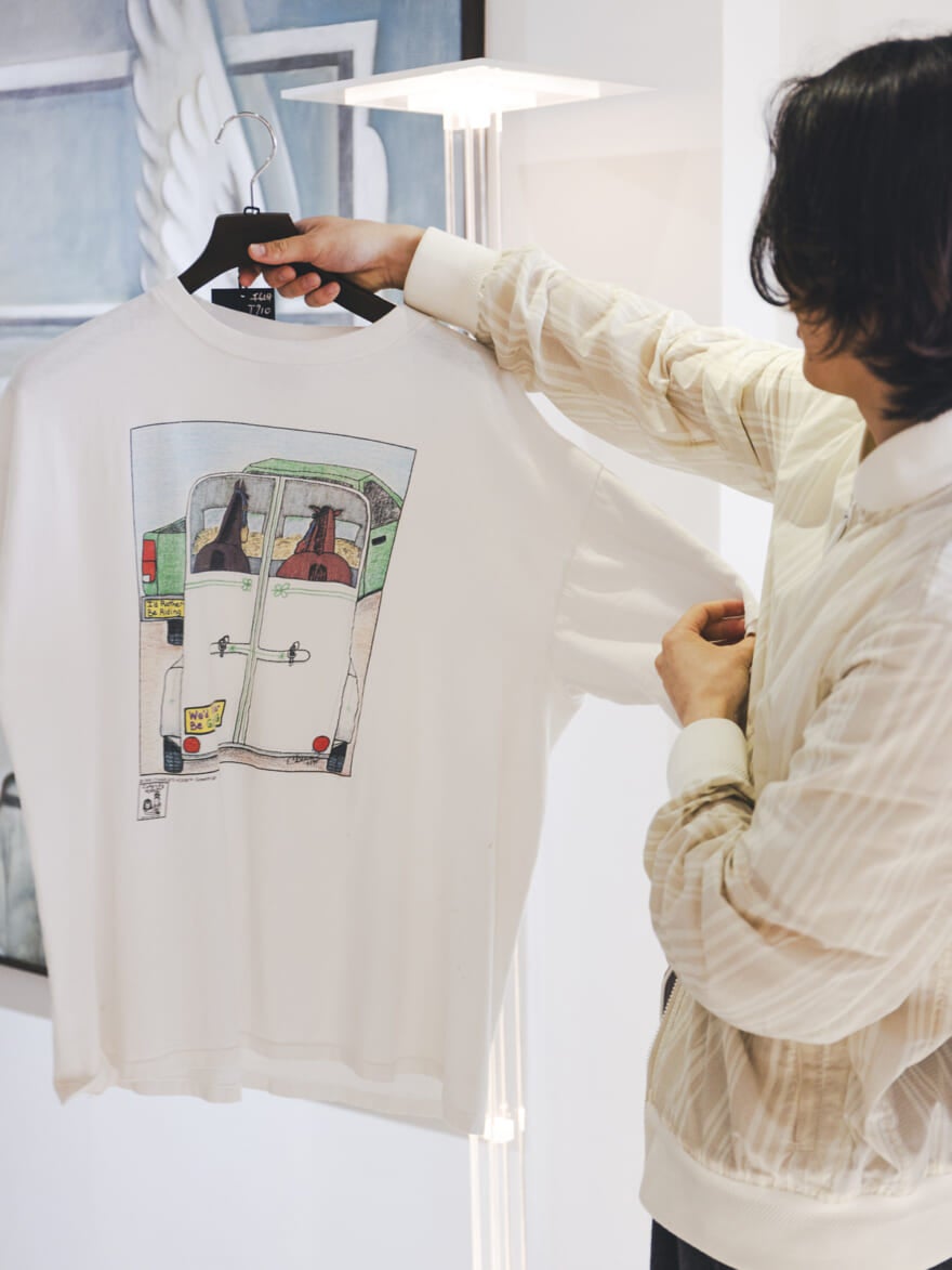 馬が描かれたTシャツを手に取る根本さん