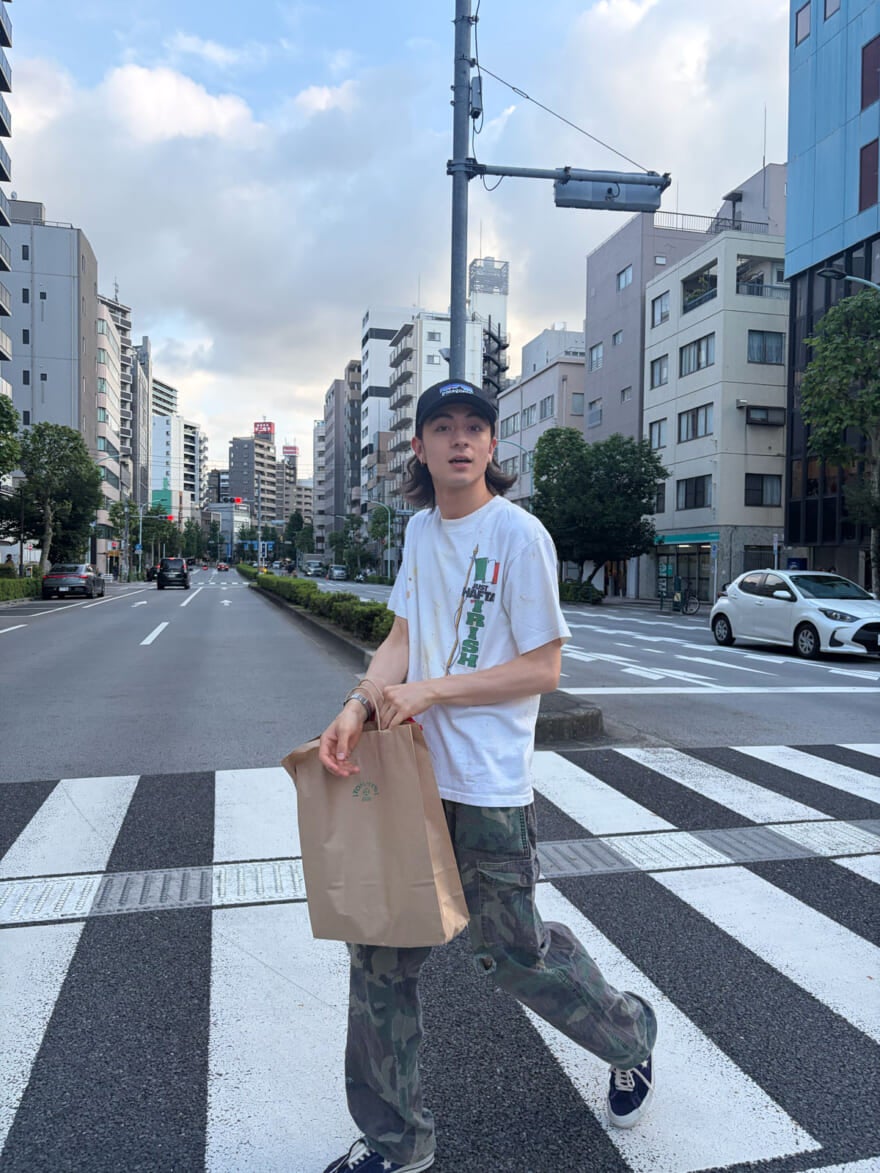 茶色の大きな紙袋を持った買い物帰りの松岡