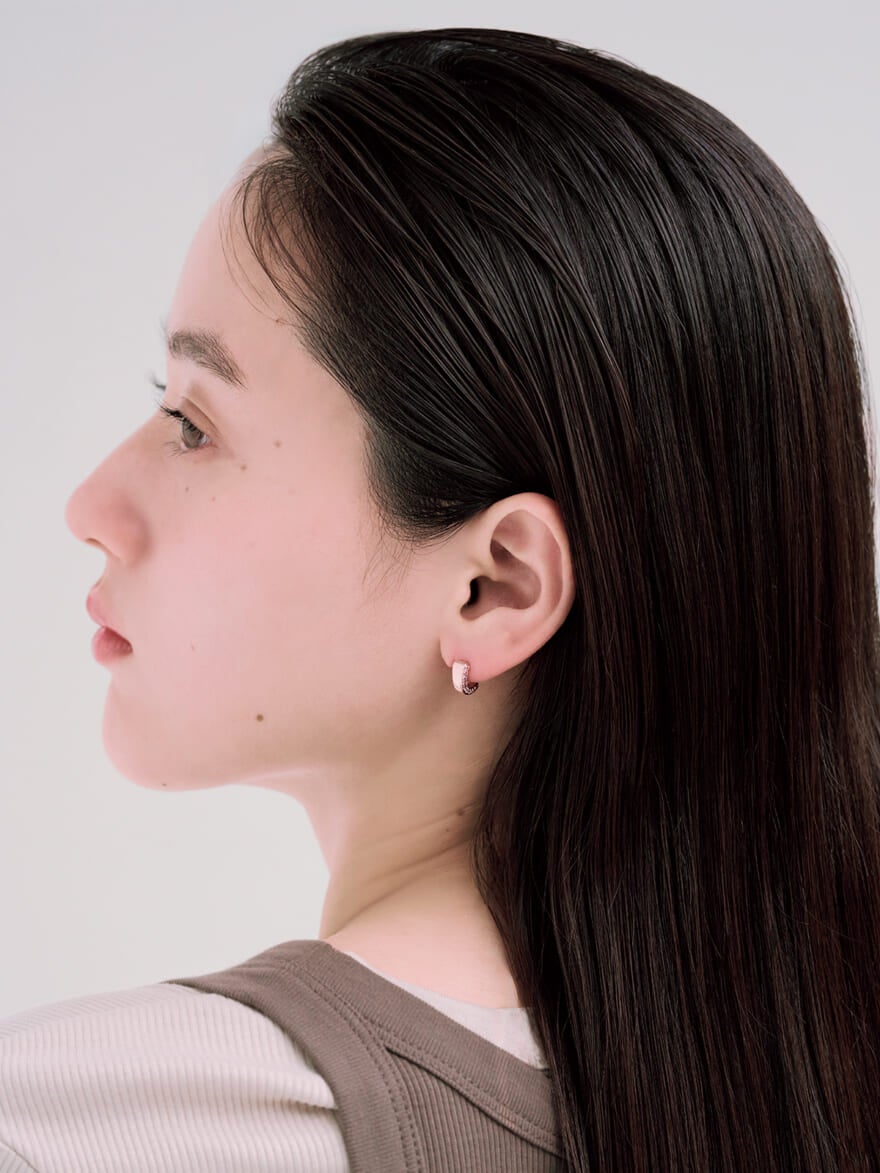 Jouete(ジュエッテ)のピンクゴールドとジルコニアのピアスを着用した女性モデル