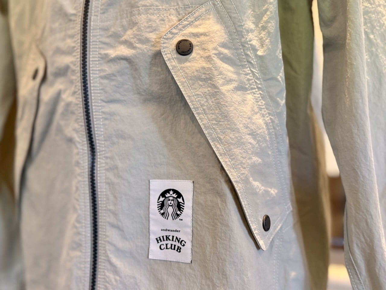 「and wander +STARBUCKSナイロンタフタフーディージャケット アイボリー」ポケット