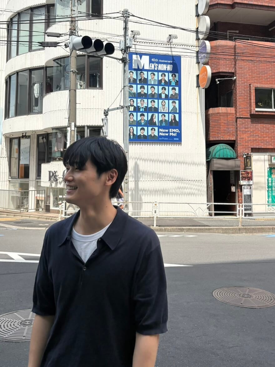 中川大輔と、その背景に映るメンズノンノの看板広告