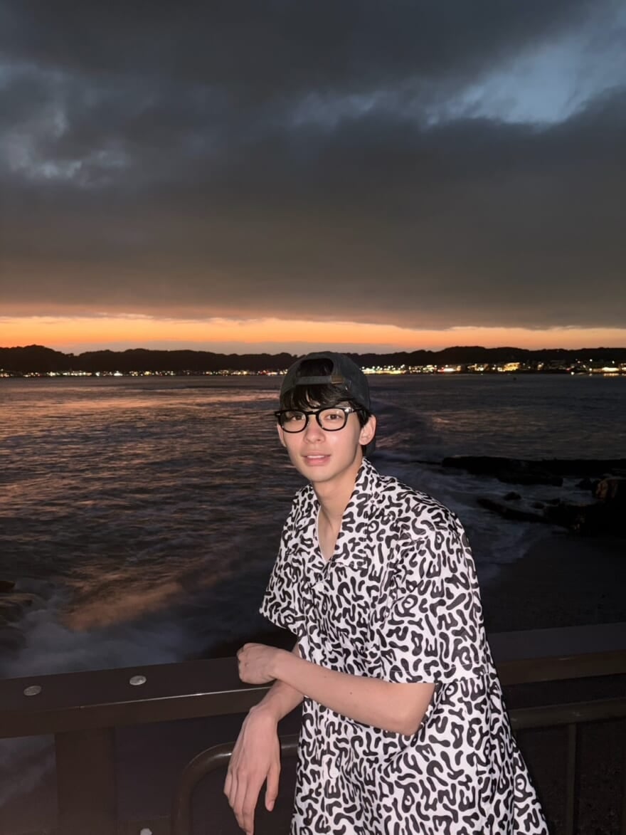 夜の海の前に立つ松井大奈